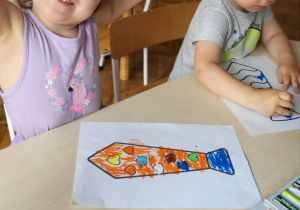 dziecko koloruje pracę plastyczną krawat