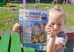 Dziewczynka z ilustracją bądź bezpieczny w górach