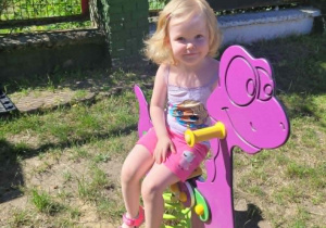 Diewczynka na bujaku dinozaura