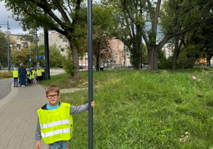 Chłopiec stoi obok znaku dla pieszych i rowerów
