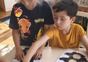 Dwóch chłopców wykleja papierem sygnalizator świetlny