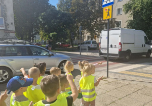 Dzieci stoją przed znakiem drogowym