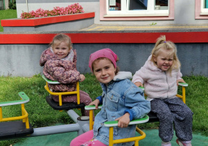 Trzy dziewczynki siedzą na karuzeli