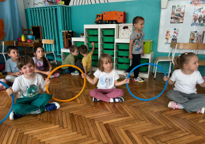 Dzieci trzymają kolorowe obręcze