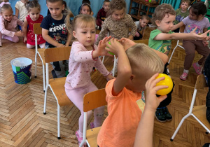 Dzieci podają sobie piłeczkę nad głową