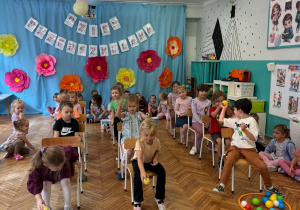 Dzieci sięgają piłeczki kolorowe z obręczy