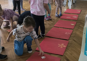 dzieci układają liście na podłodze