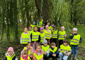 dzieci stoją pod drzewem