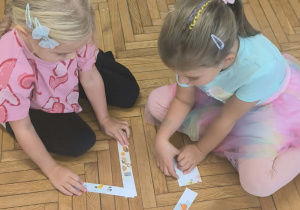 dwie dziewczynki układają puzzle piramidę zdrowia