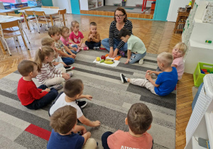 dzieci siedzą z panią na dywanie