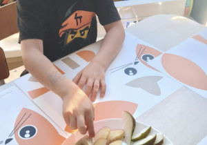 Chłopiec sięga po kawałek banana