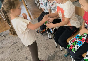 Dziewcyznka wręcza chłopcu prezent