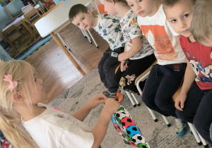 Dziewczynka podaje chłopcu prezent