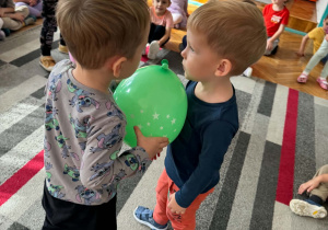 dwóch chłopców trzyma balon