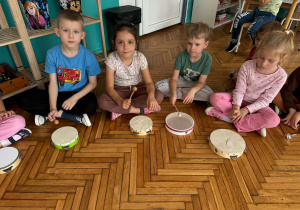 dzieci siedzą przed bębenkami