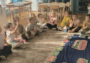 dzieci siedzą na dywanie