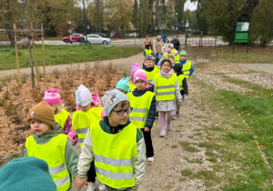 dzieci idą w kamizelkach odblaskowych