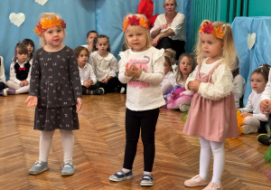 Trzy dziewczynki mają na głowach opaski z liścmi