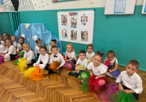 Dzieci siedzą z kolorowymi apaszkami