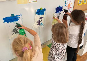 Dzieci spryskiwaczem tworzą deszcz