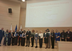 Nagrodzone osoby stoja na scenie