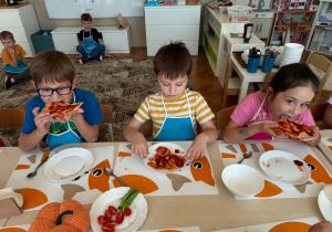 dzieci jedzą pizzę
