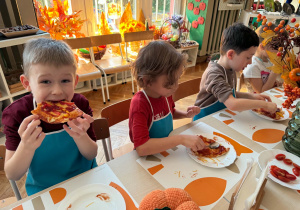 chłopcy jedzą pizzę