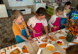 dziewczynka kładzie ser na pizzę