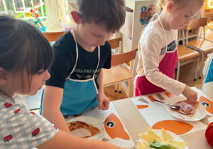 dziewczynka sięga wędlinę z talerza