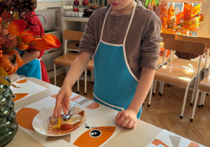 chłopiec dekoruje pizzę