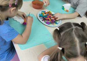 dzieci wyklejają talerzyk bibułą