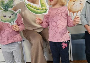 dziewczynki pokazują kukiełki warzyw