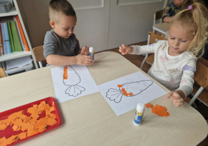 dziewczynka i chłopiec wykonują marchewki