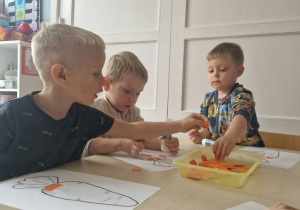 dzieci wykonują pracę plastyczną