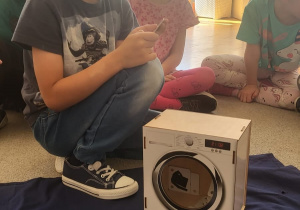 chłopiec wyciąga z pralki wyraz i określa głoskę w nagłosie