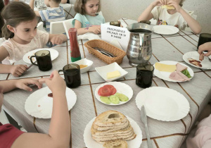 trzy dziewczynki siedzą i jedzą śniadanie