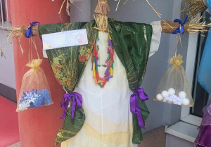 kukła Marzanny wykonana przez dzieci z grupy czwartek wykonana ze słomy w bialej sukience, zielonej chuście oraz gniazdem bocianim na głowie