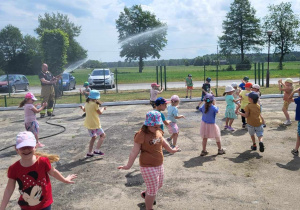 dzieci zostały polane przez strażaków wodą z węża strażackiego