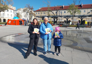 Rodzice i dzieci pozują do zdjęcia z naszymi ulotkami