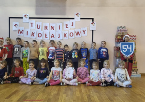 Wszystkie dzieci pozuja na tle napisu "Turniej mikołajkowy"