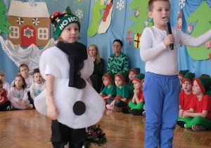 Chłopiec z Balwankiem zapraszają do zaśpiewania kolędy