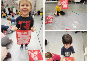 dzieci pokazują swoje prace plastyczne na czerwonym kartonie namlaowane białą farba wzory