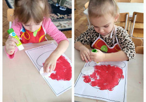 dzieci za pomocą gabki odciskają na papierze z narysowaną czapką Mikołaja stemple z czerwonej farby