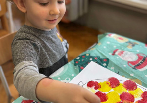 Chłopiec stempluje balon żółtą farbą