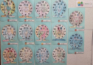 praca plastyczna kolorowe zegary ymieszczone w szatni przedszkolnej jako ozdoba wykonana przez najmłodszą grupę