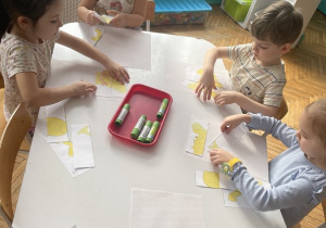 Dzieci skladają obrazek z części Kubuś Puchatek