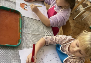 Dziewczynki malują farbami postać Misia Uszatka