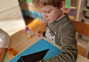 Chłopiec nakleja wilka z origami