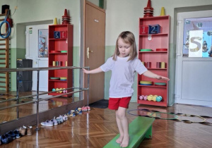 dziewczynka idzie po ławeczce