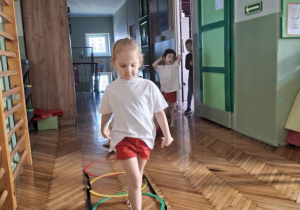 dziecko przechodzi po grabince gimnastycznej
